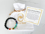 chakra bracelet laying on a white velvet pouch and bracelet card