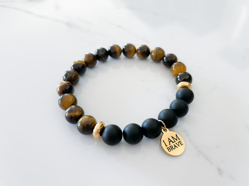 side view of the brave bracelet with tiger's eye and onyx crystals and I am brave gold charm