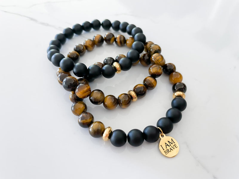 three piece brave bracelet with a tiger's eye and onyx stack to create a bold fashion accessory for motivation and empowerment. This affirmation charm is a daily reminder to be brave, strong, and courageous